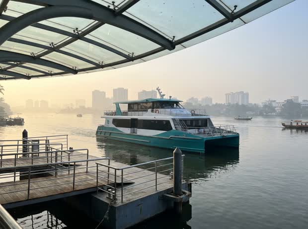 A modern water-metro catamaran ferry at a floating jetty